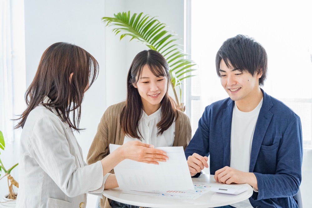 書類を手に打ち合わせ・相談に対応するスタッフ